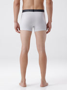 Person wearing white boxer briefs with a black waistband on a white background