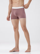 Man wearing a mauve boxer brief with a white waistband on a white background