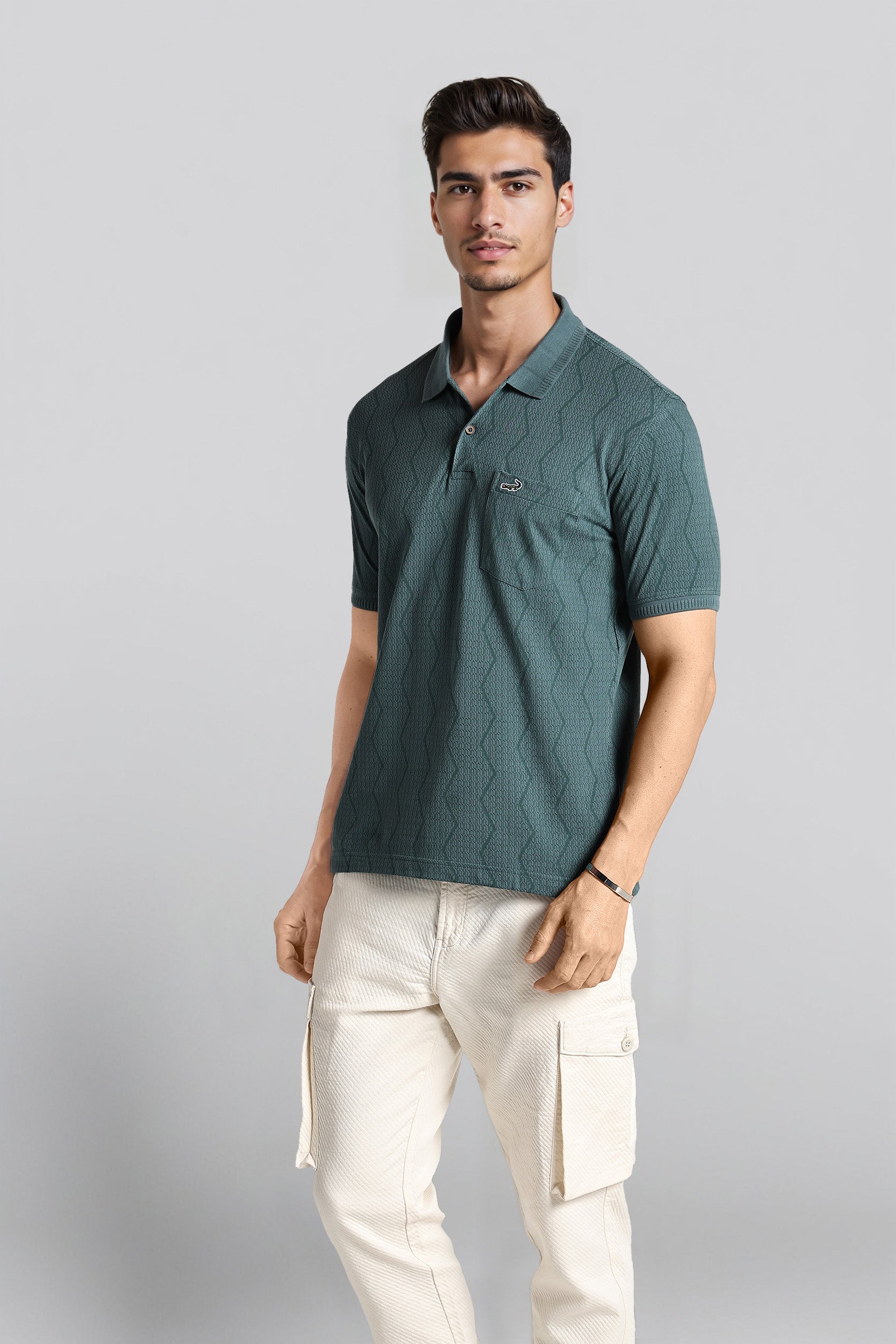 Man wearing a green polo shirt and white pants on a gray background