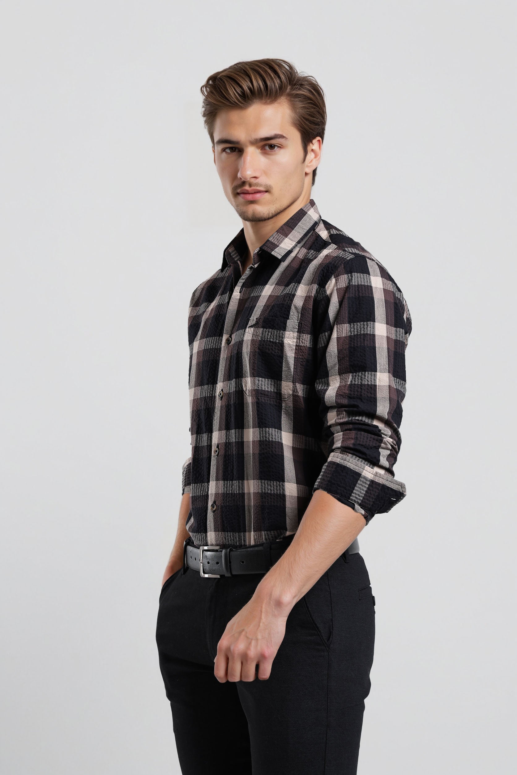 Man wearing a black and white plaid shirt on a light gray background