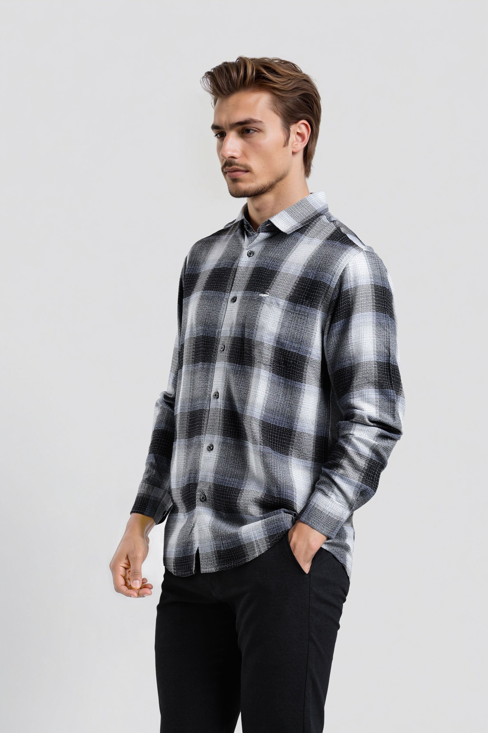 Man wearing a black and gray plaid shirt on a white background