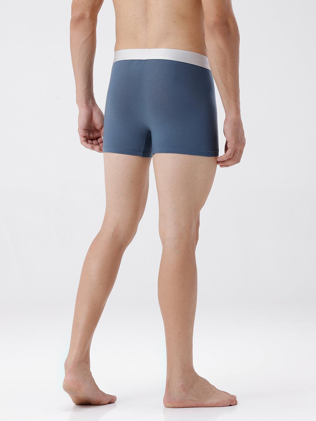 Person wearing a pair of blue boxer briefs on a white background
