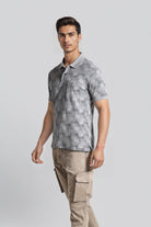 Man wearing a gray patterned polo shirt and beige cargo pants on a light gray background