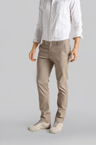 Person wearing beige pants and a light shirt on a gray background