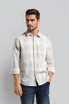 Man wearing a checkered shirt and jeans on a gray background