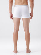 Person wearing a white boxer brief on a plain background