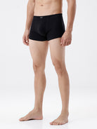 Person wearing black boxer briefs on a white background