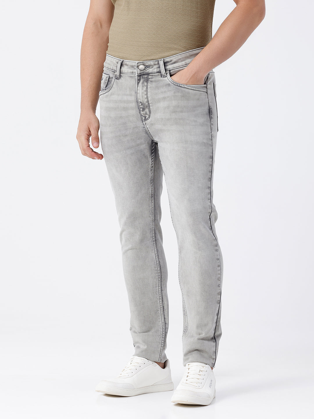Man wearing a grey light grey knit slim fit jeans on a light gray background