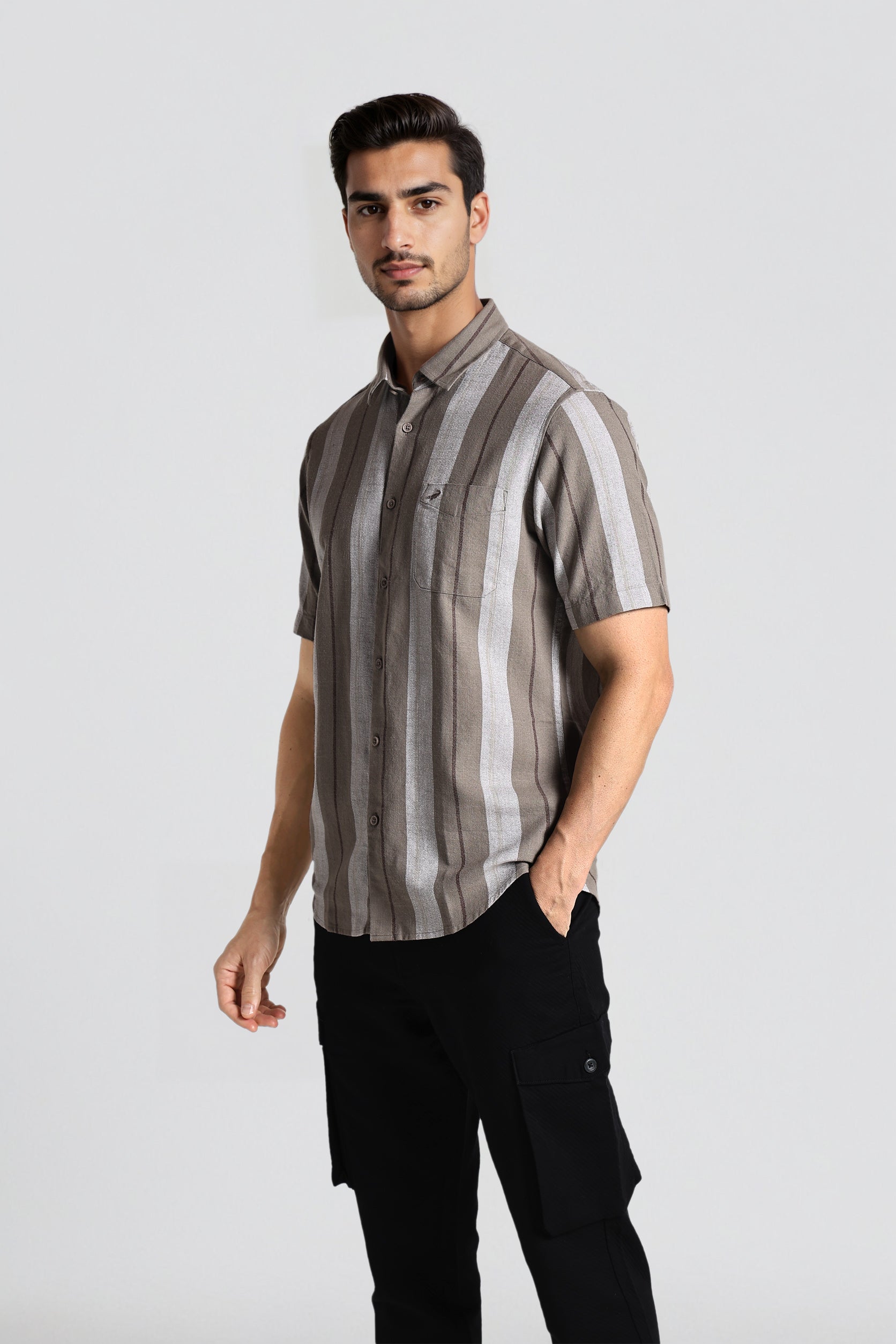 Man wearing a striped shirt and black pants on a white background