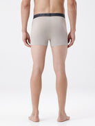 Person wearing beige boxer briefs on a white background