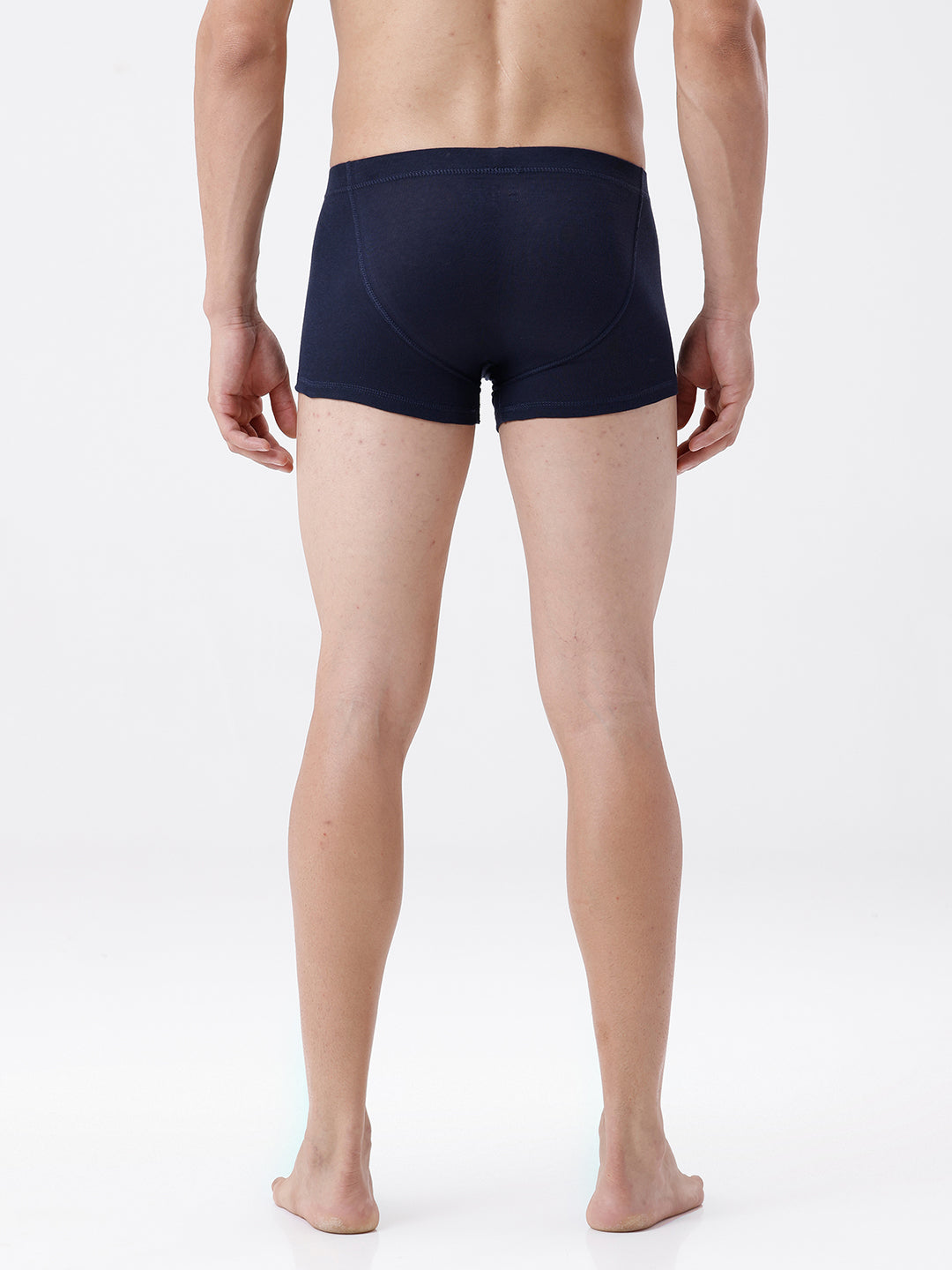 Person wearing navy blue boxer briefs on a white background