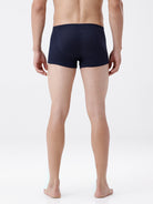 Person wearing navy blue boxer briefs on a white background