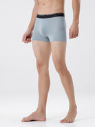 Person wearing light gray boxer briefs with a black waistband on a white background