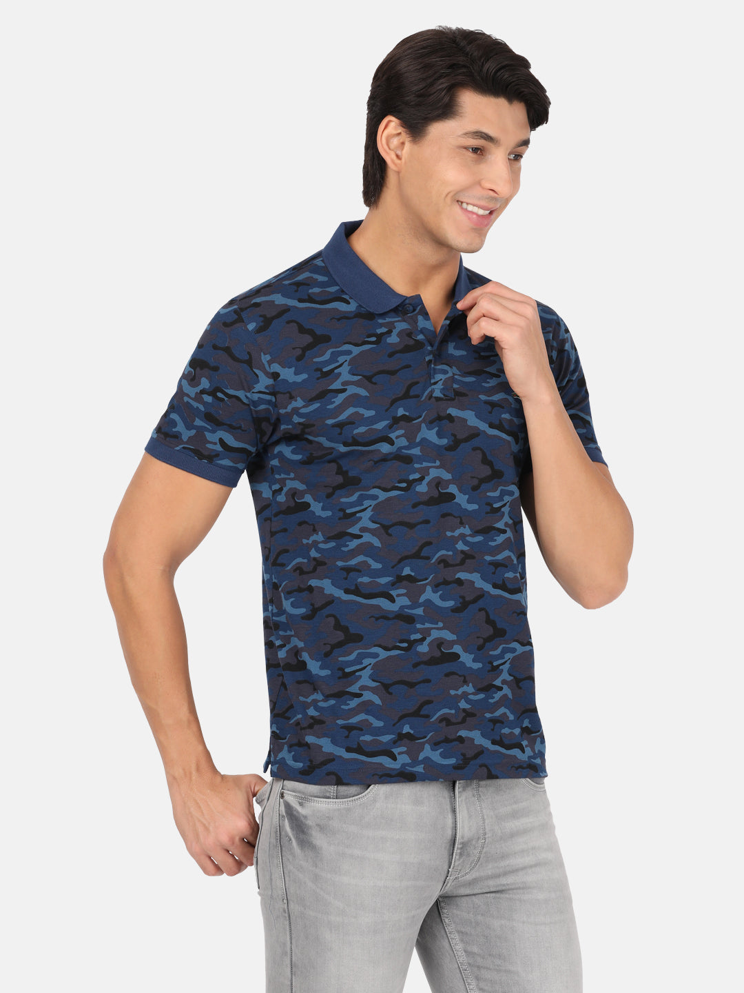 Man wearing a blue royal blue printed polo t shirt with casual styling on a gray background