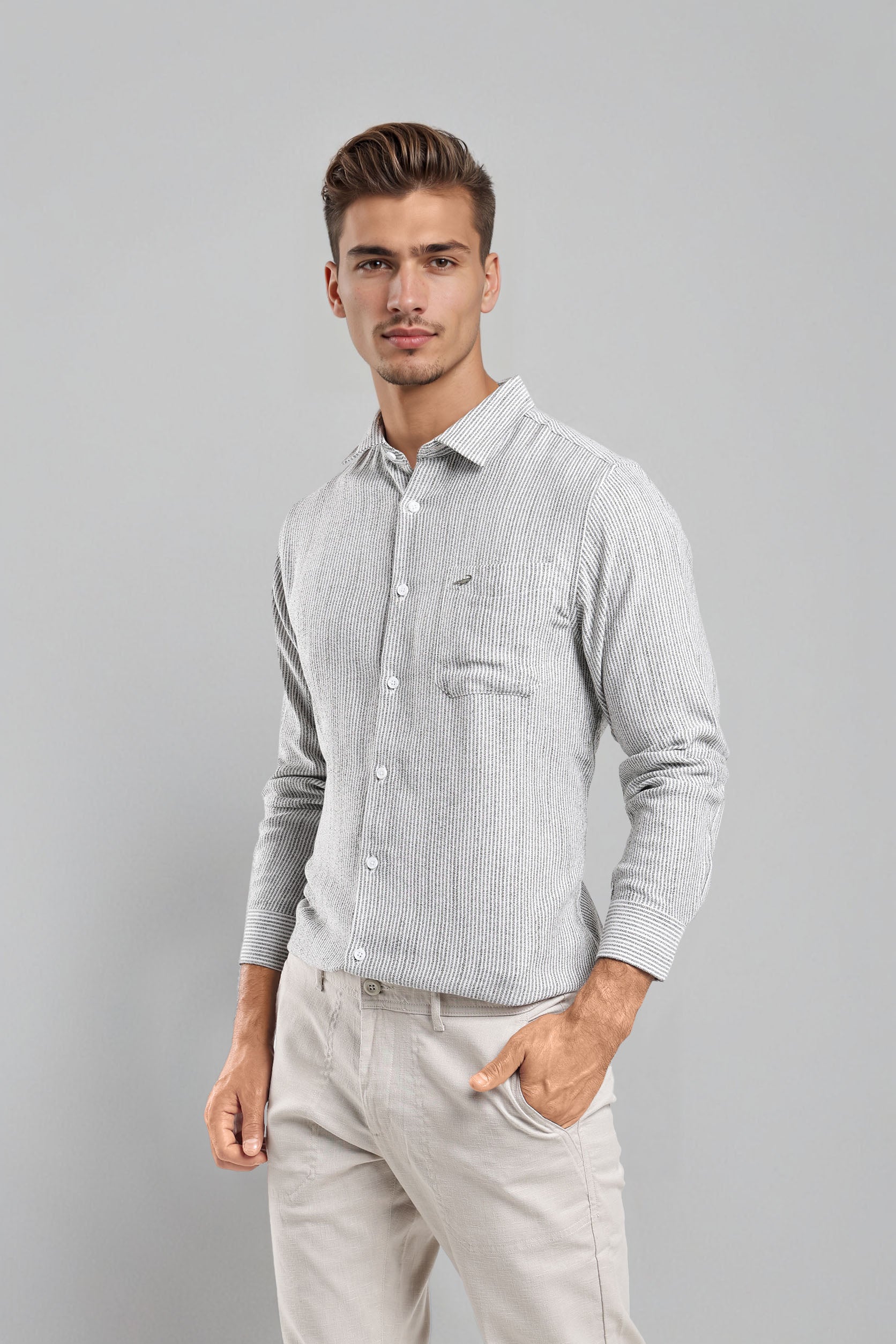 Man wearing a light gray checkered shirt and beige pants against a gray background