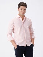 Man wearing a geomentic diamond print shirt orange on a light gray background