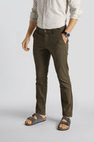 Person wearing olive green pants and sandals on a light gray background