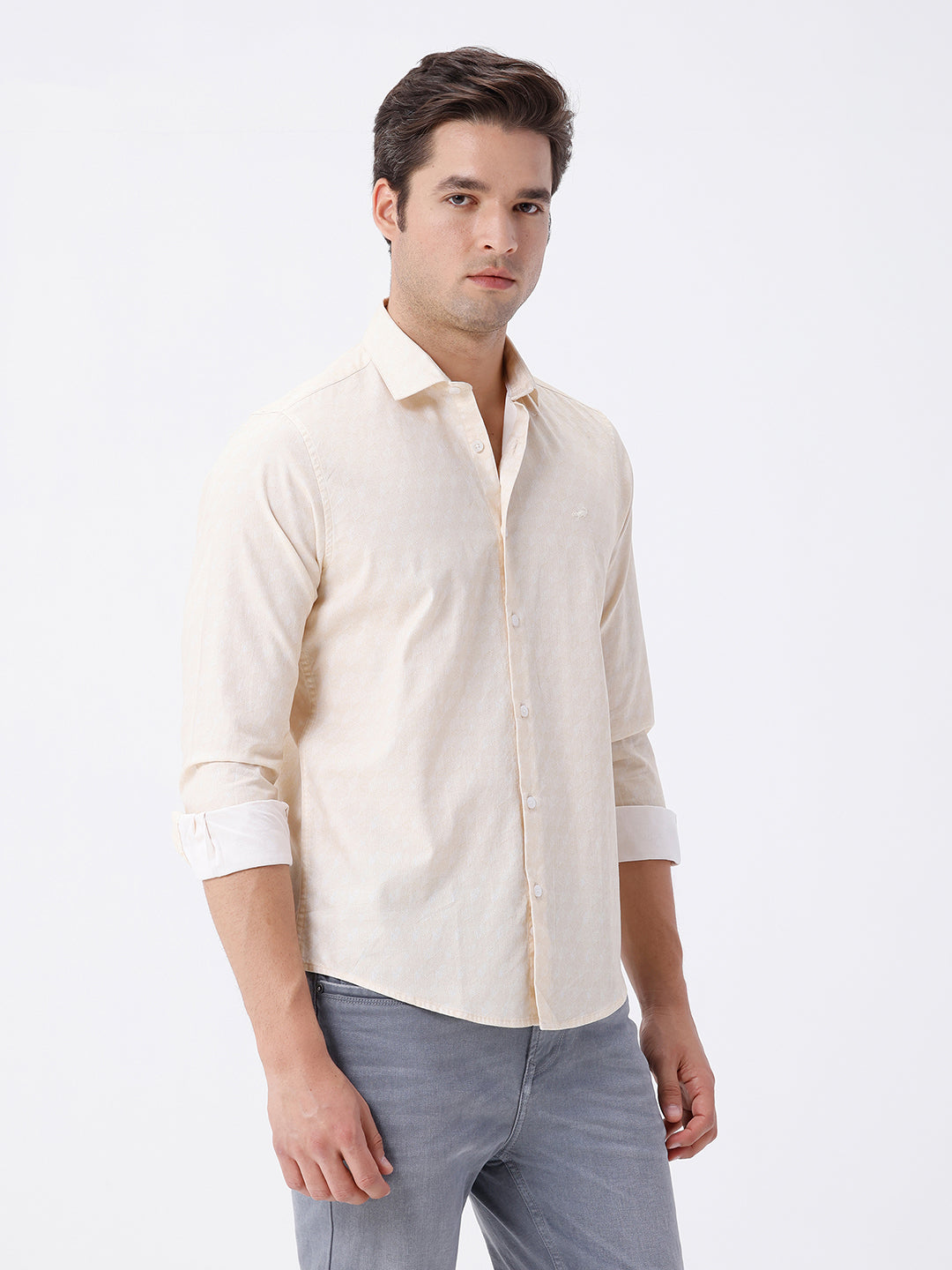 Man wearing a geomentic diamond print shirt on a light gray background
