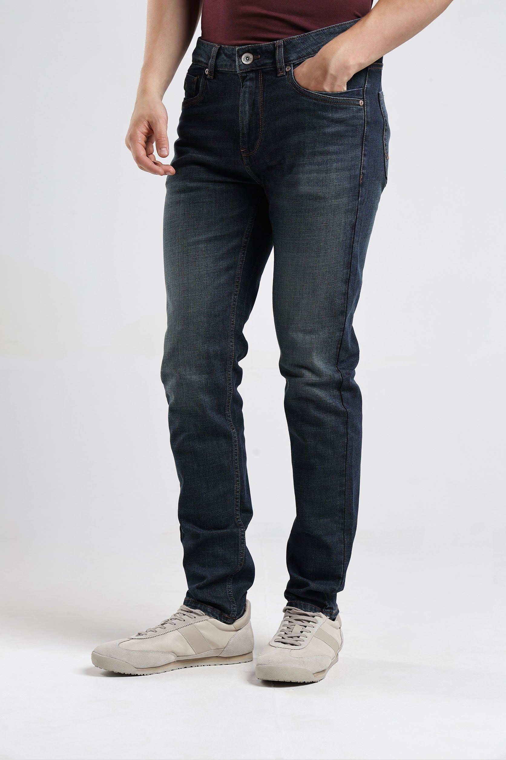 Person wearing dark blue jeans on a white background