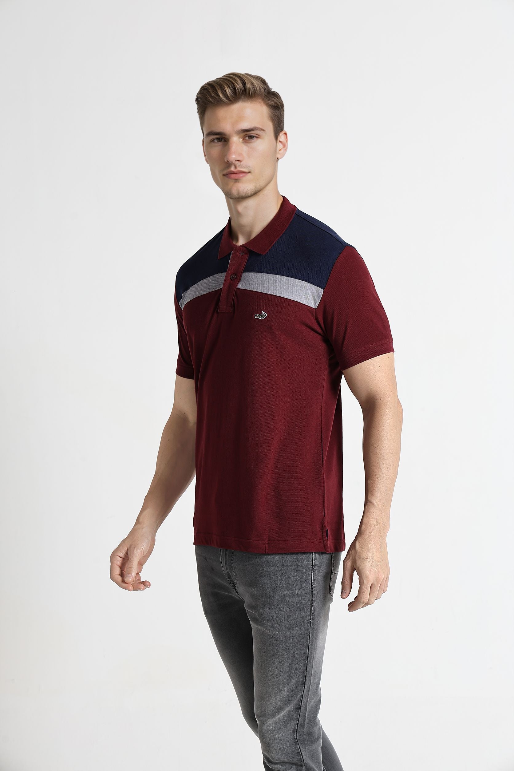 Man wearing a maroon and navy polo shirt with a logo on a white background
