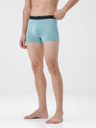 Person wearing light blue boxer briefs with a white background