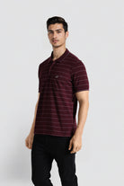 Man wearing a maroon striped polo shirt on a white background