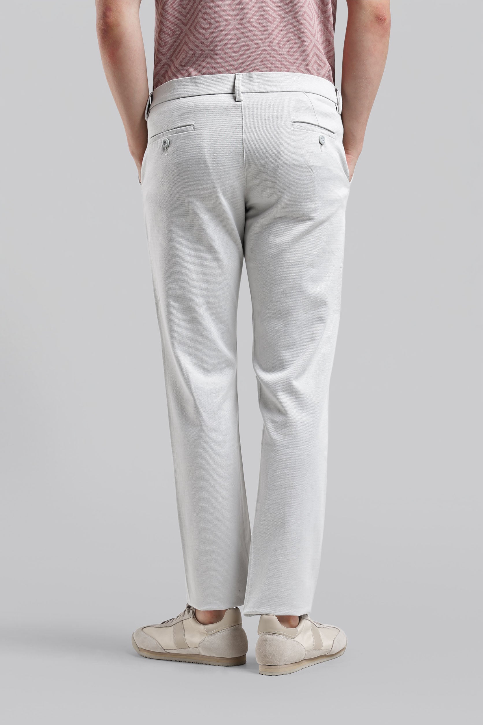 Person wearing light gray pants on a plain background