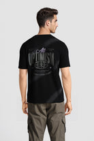 Man wearing a black t-shirt with text on the back against a light gray background