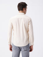 Man wearing a geomentic diamond print shirt on a light gray background