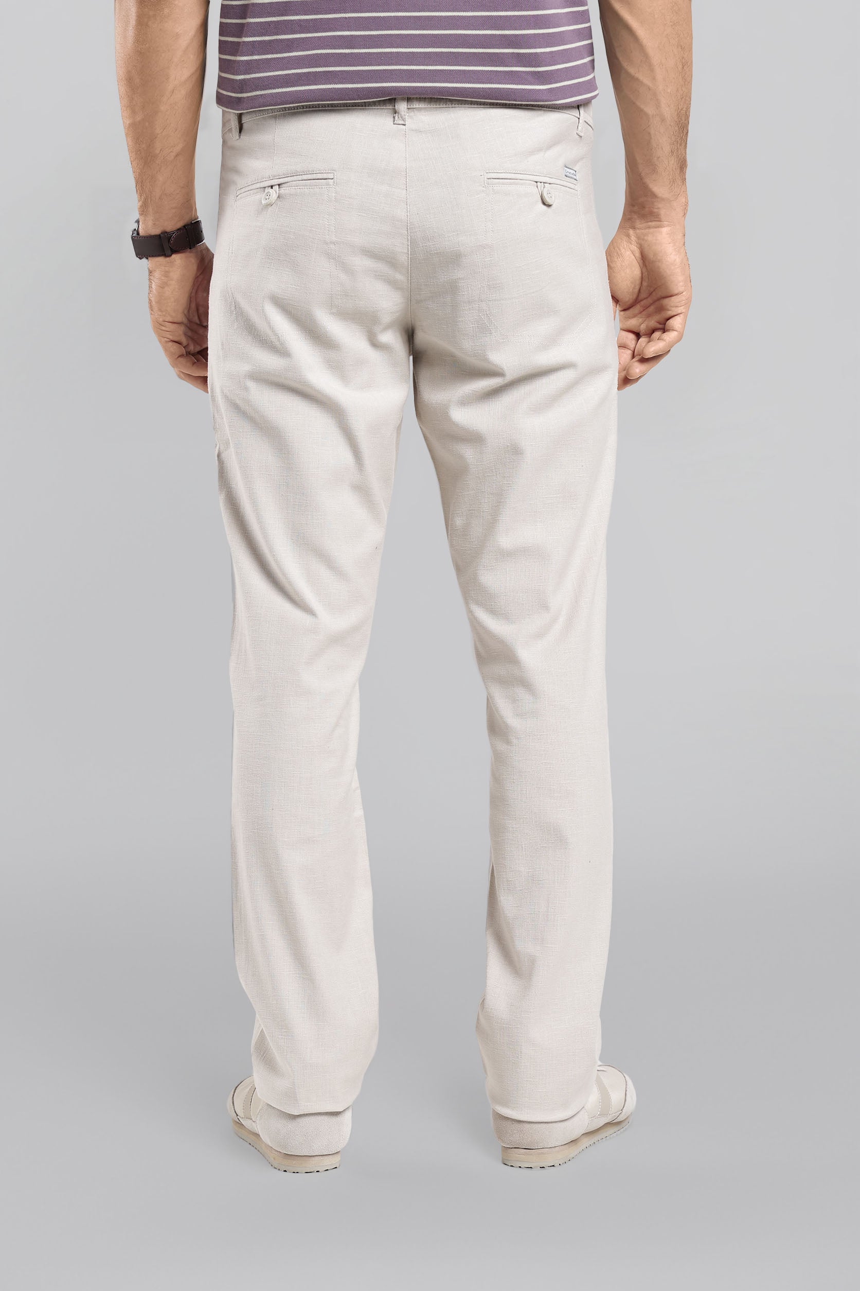 Person wearing light-colored pants on a gray background