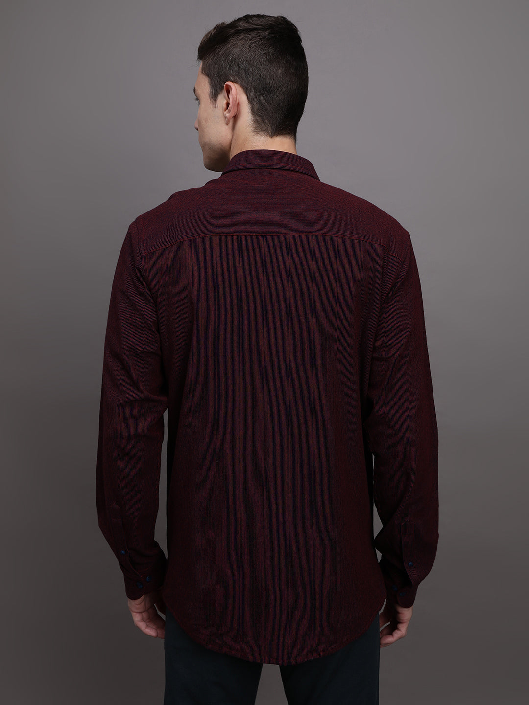 Man wearing a red red striped full sleeve 100% cotton shirt on a light gray background