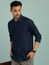 Man wearing a navy checked navy full sleeve casual 100% cotton shirt with casual styling on a gray background