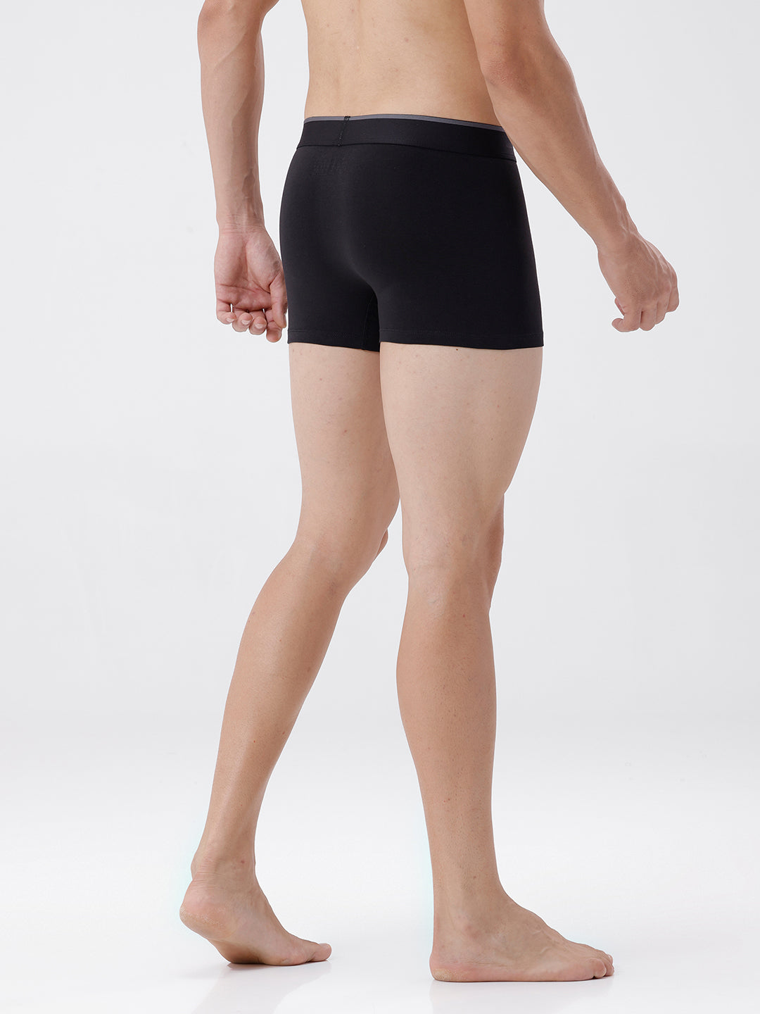Person wearing black boxer briefs on a white background