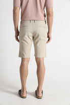 Person wearing beige shorts and a pink shirt on a white background
