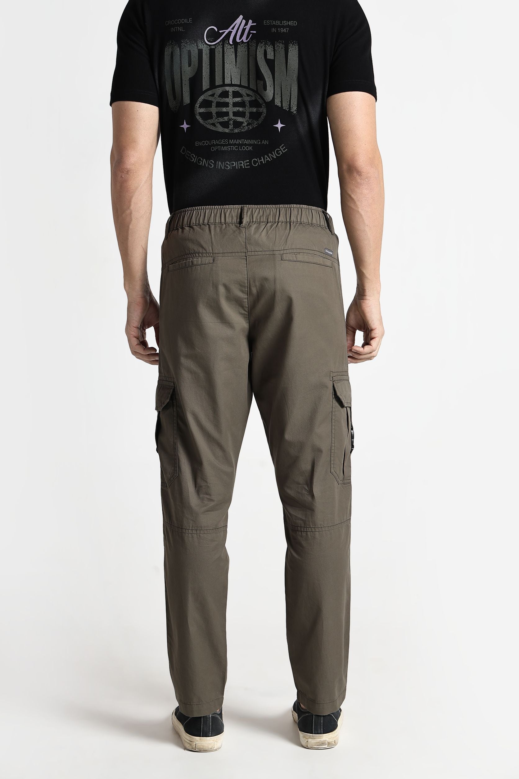 Person wearing a black t-shirt with text and graphics, paired with olive green cargo pants on a white background