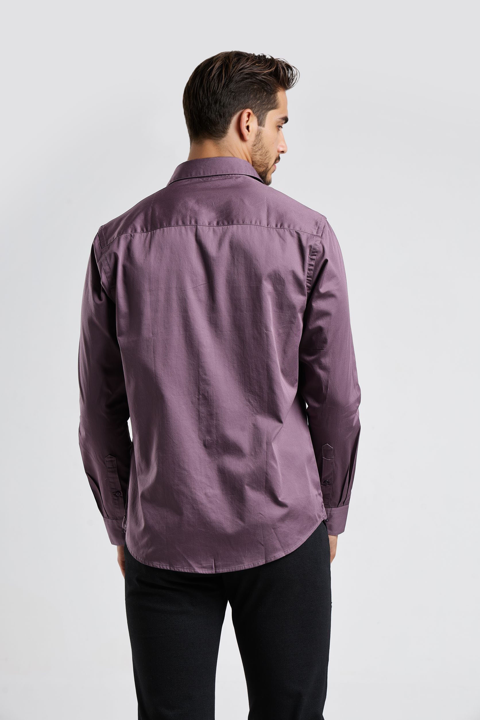 Man wearing a purple shirt from behind on a white background