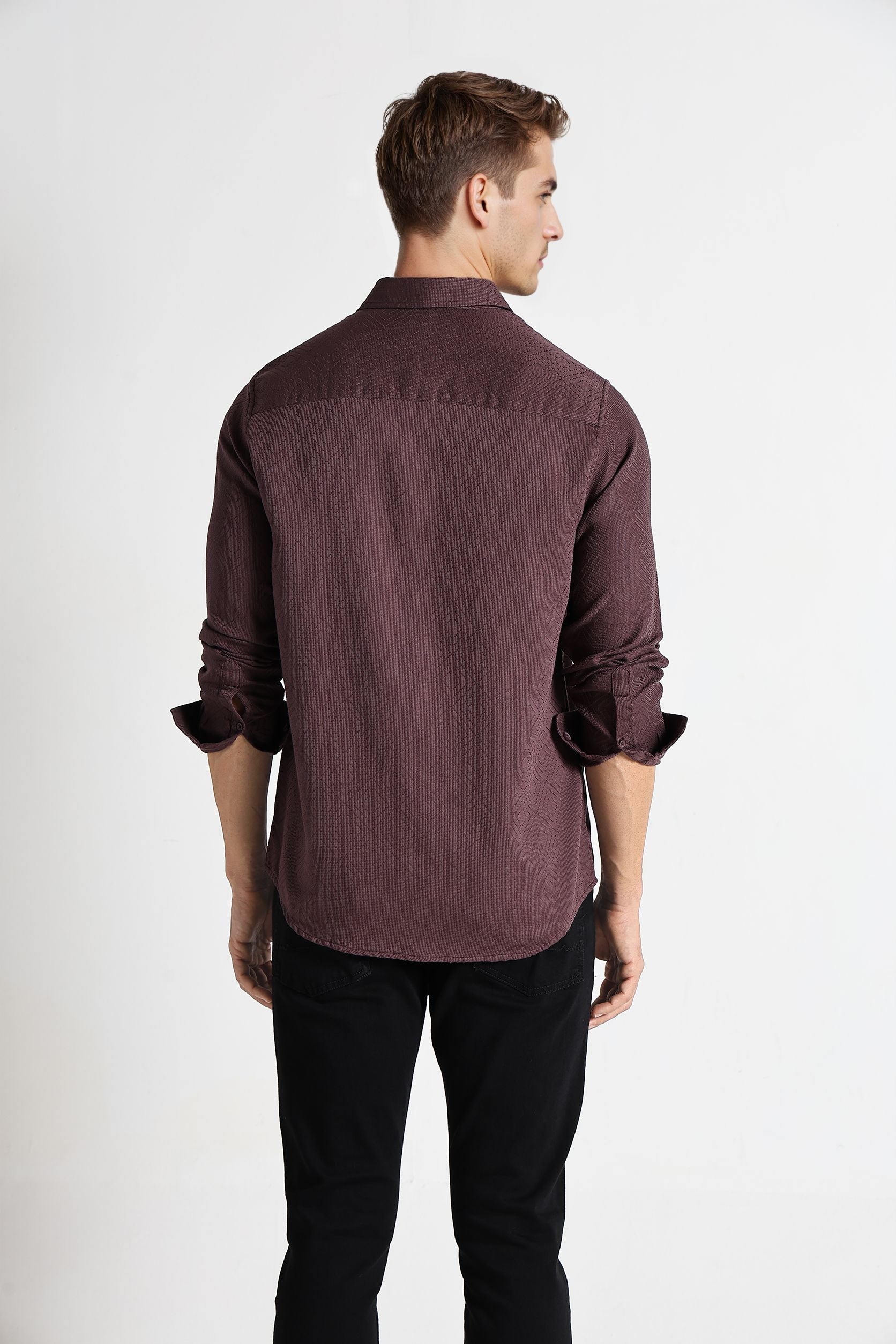 Man wearing a brown shirt with rolled-up sleeves on a white background