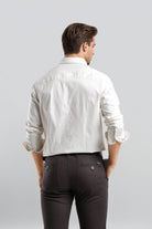 Man wearing a white shirt and dark pants on a light gray background