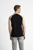 Man wearing a black and beige sleeveless shirt on a white background