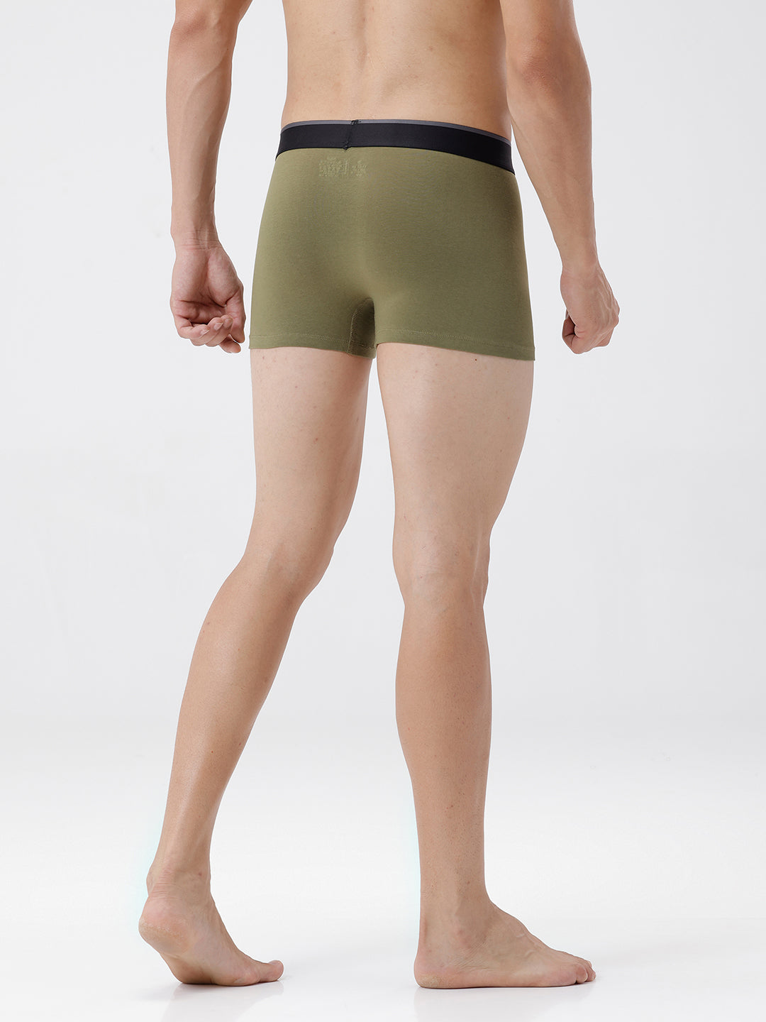 Person wearing olive green boxer briefs on a white background
