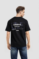 Man wearing a black t-shirt with graphic design on the back against a light gray background