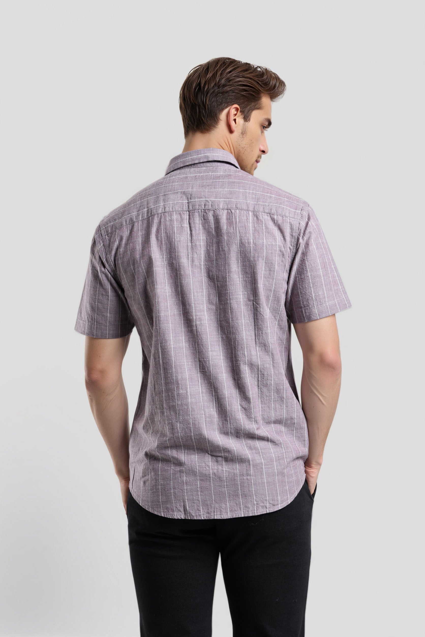 Man wearing a short-sleeve checkered shirt against a plain background