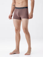 Man wearing brown boxer briefs on a white background