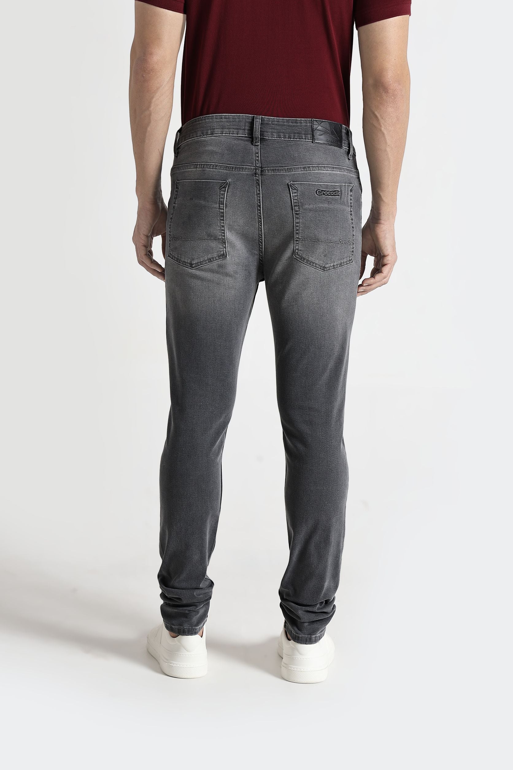 Person wearing gray jeans on a white background