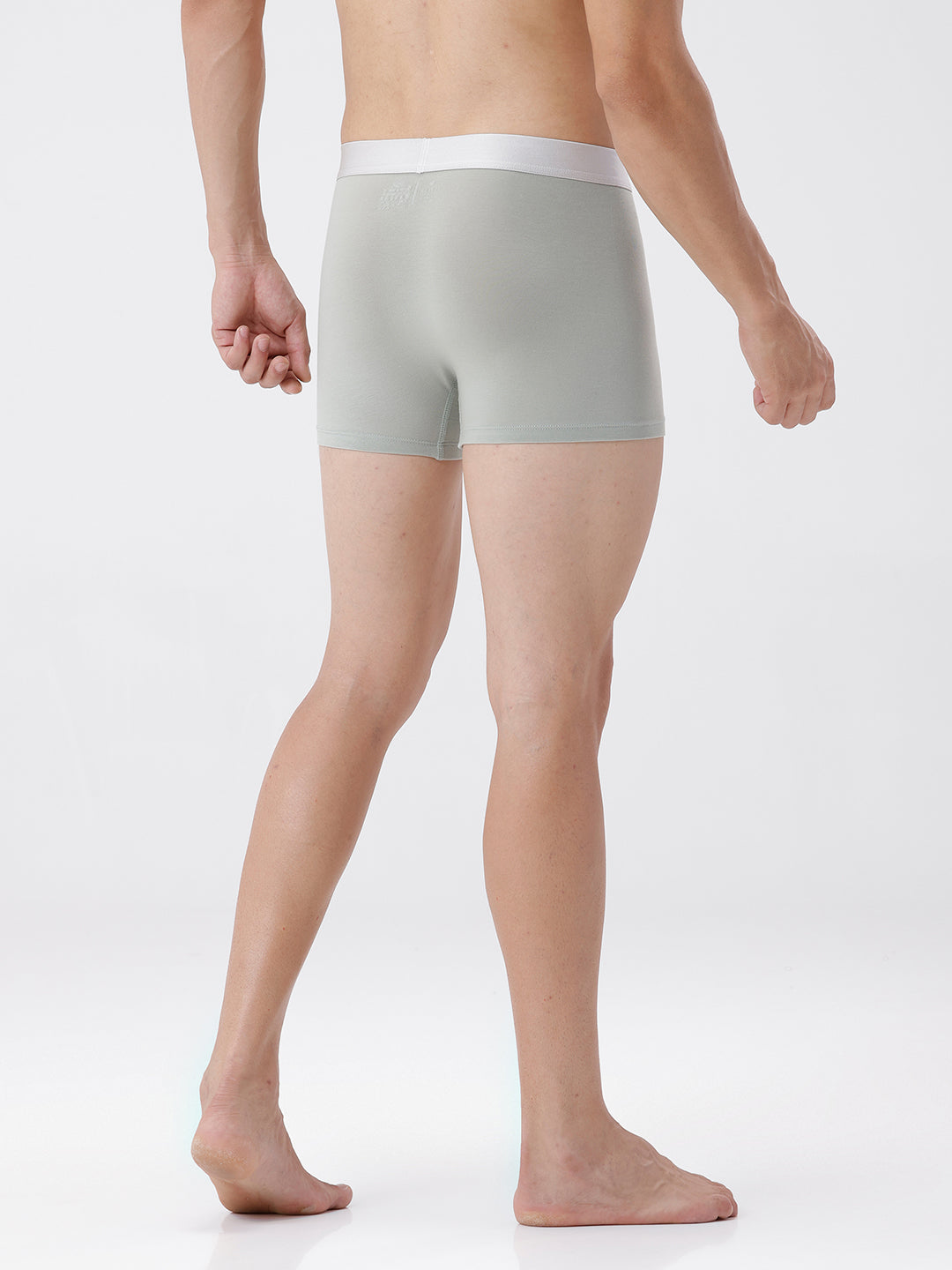 Person wearing light gray boxer briefs on a white background