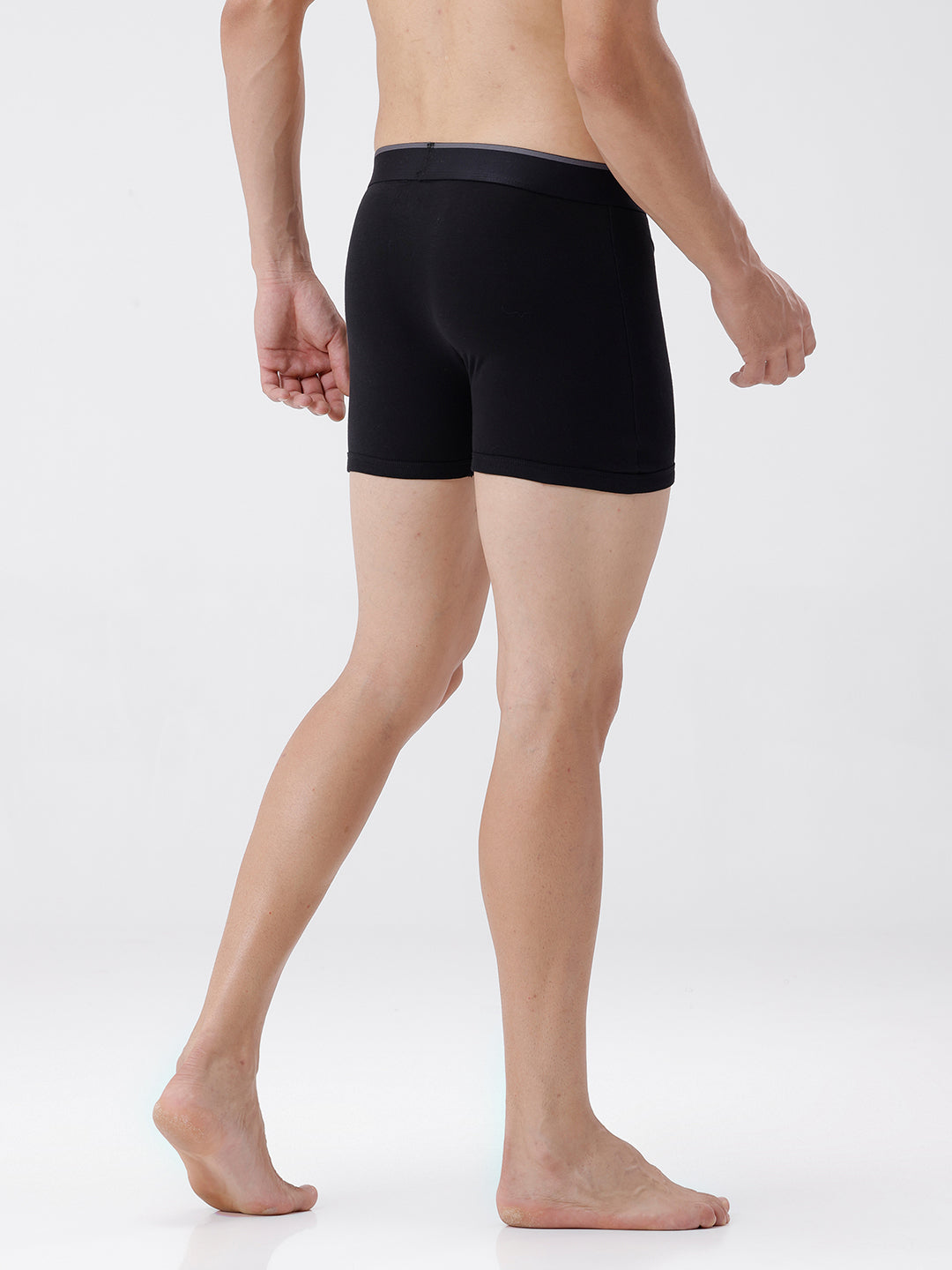 Person wearing black boxer briefs on a white background
