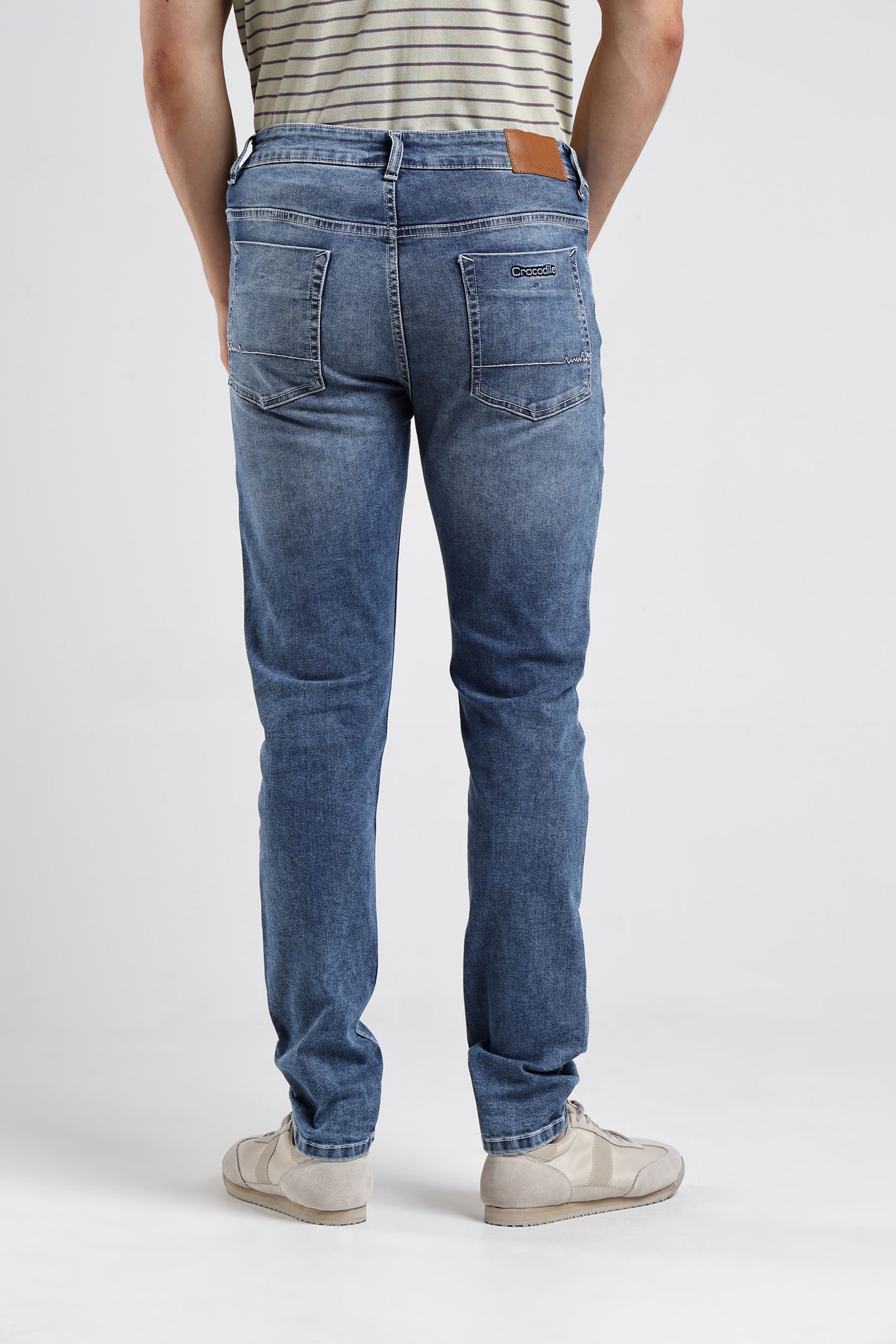 Person wearing blue jeans on a white background
