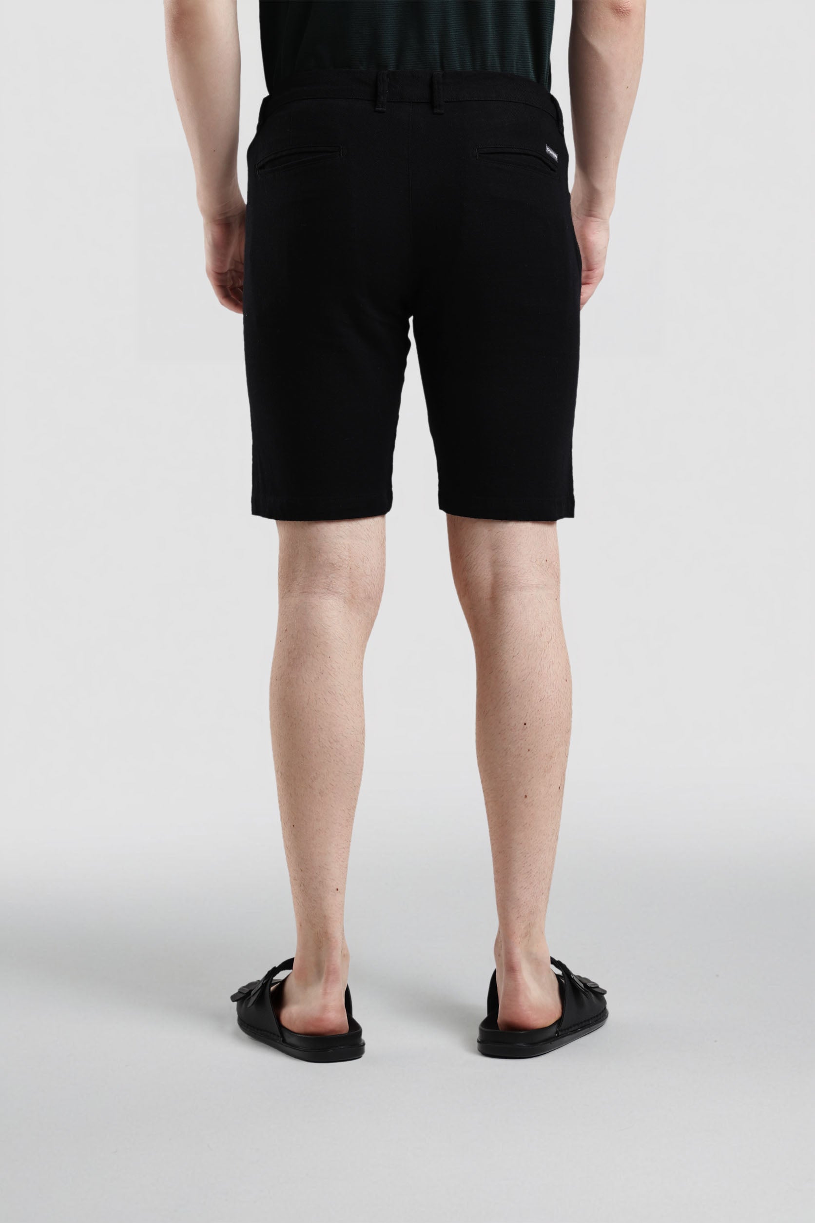 Person wearing black shorts on a white background