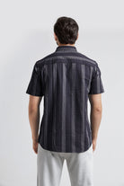 Man wearing a black and gray striped shirt on a white background