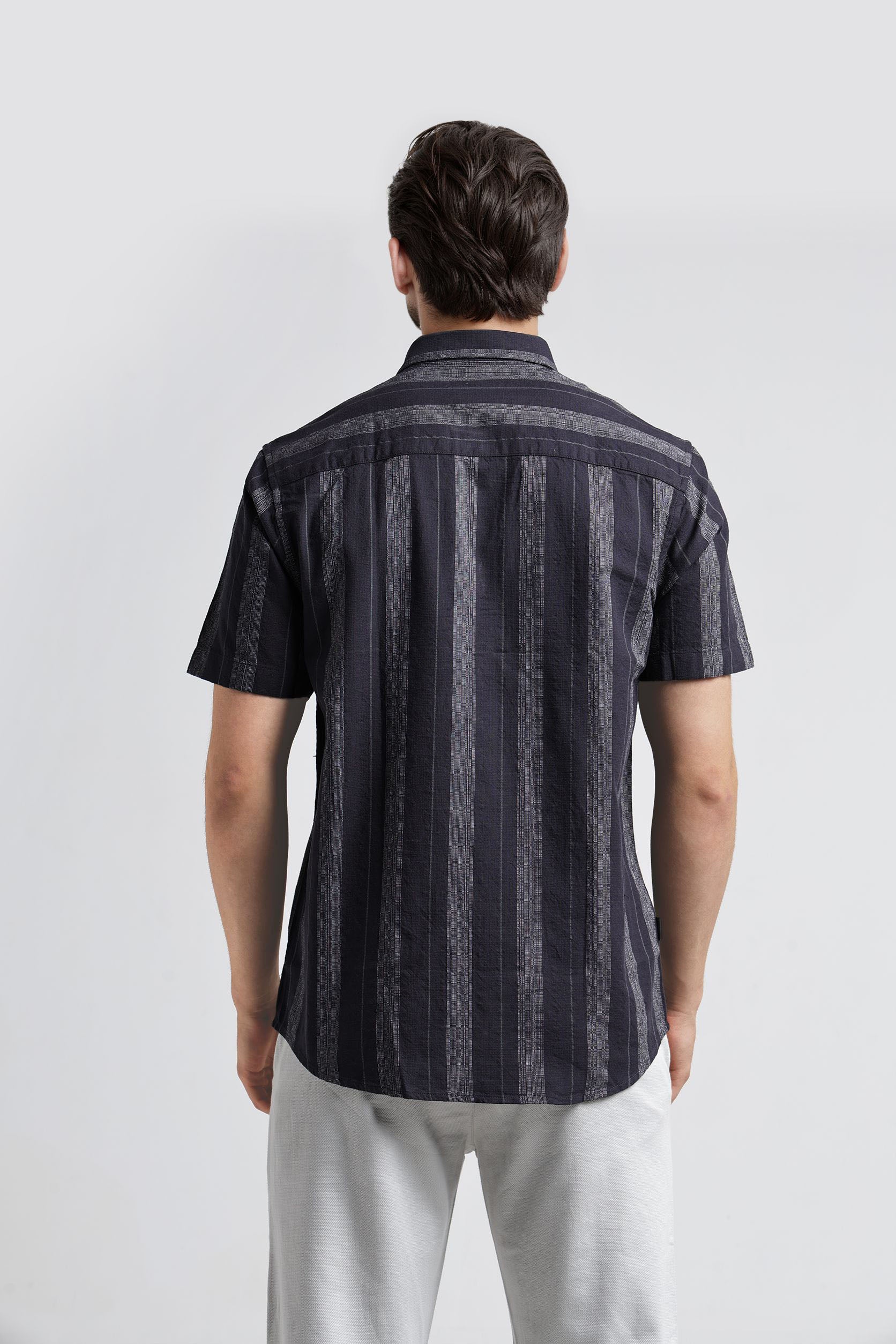 Man wearing a black and gray striped shirt on a white background